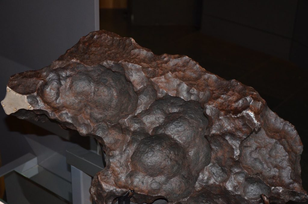 Grande masse de la météorite ferreuse Gibeon aux regmaglyptes profonds, exposée en musée