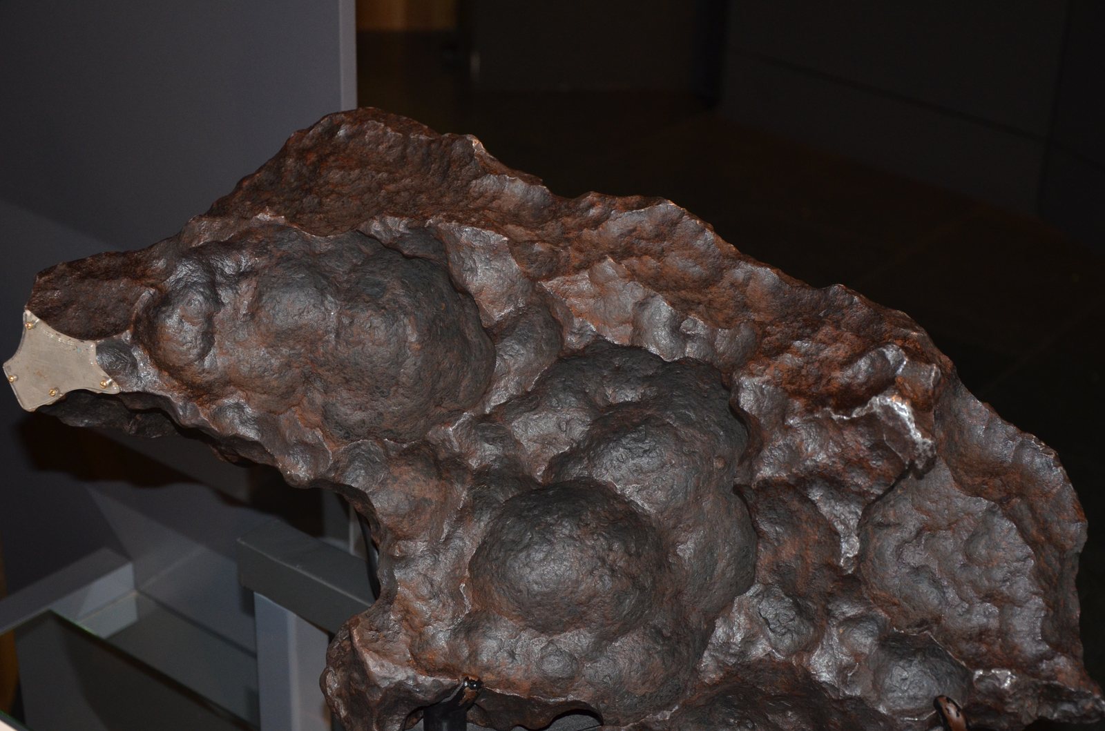 Grande masse de la météorite ferreuse Gibeon aux regmaglyptes profonds, exposée en musée