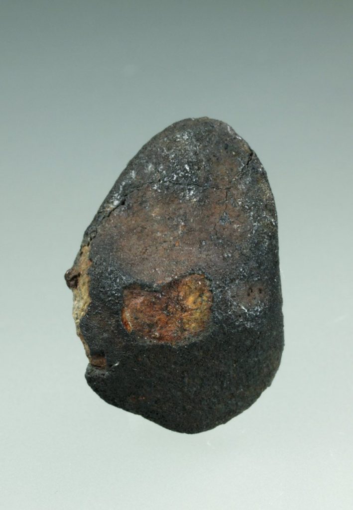 Petite météorite de Tcheliabinsk à croûte de fusion fraîche avec une fenêtre orangée