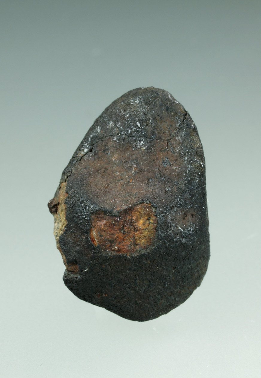 Petite météorite de Tcheliabinsk à croûte de fusion fraîche avec une fenêtre orangée