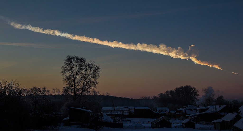 Traînée de fumée du superbolide de Tcheliabinsk dans le ciel du matin au-dessus de maisons enneigées