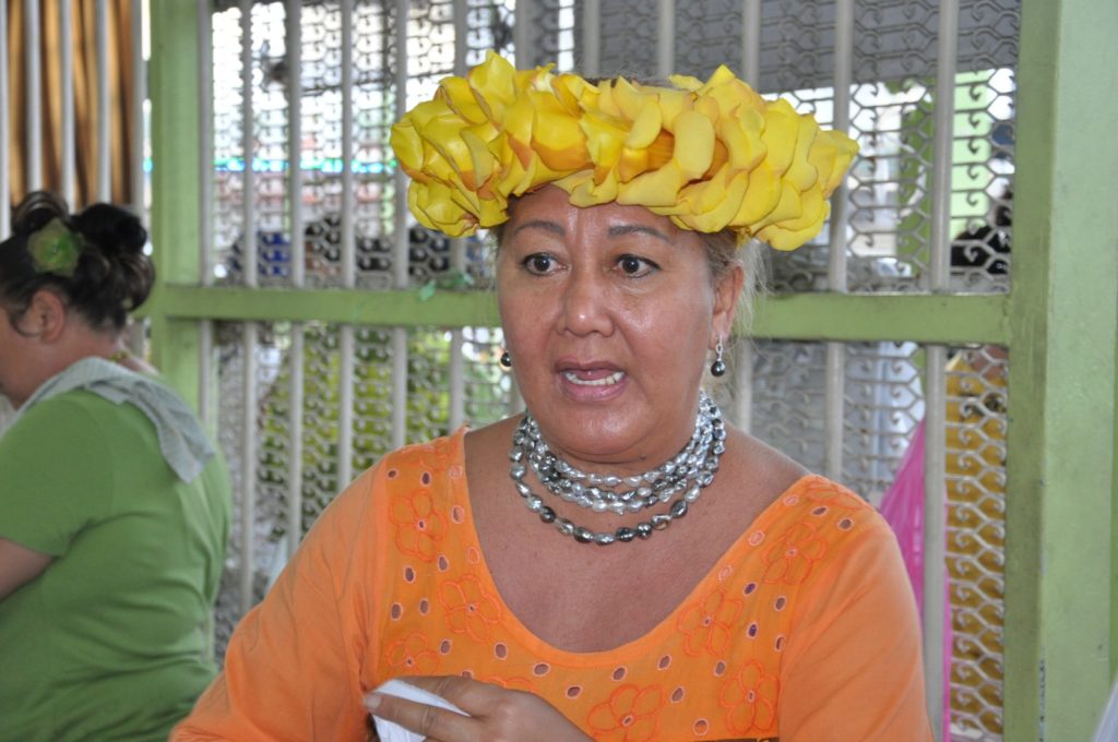 Femme portant une couronne de fleurs et un collier de perles de Tahiti