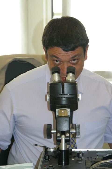 Ramon Cortes observant une gemme au microscope binoculaire